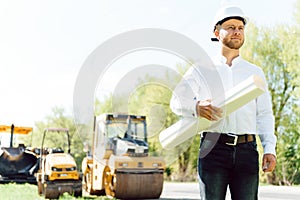 Road construction workers near asphalt paver machine. Road repair. Road service worker near the rink