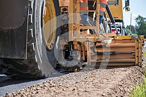 Road construction workers repairing highway road on sunny summer day