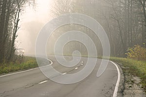 A road in the countryside is covered in fog