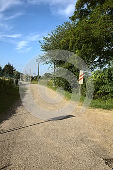 Road in the countryside that leads to a railroad crossing