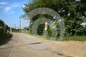 Road in the countryside that leads to a railroad crossing