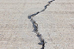 Road crack, surface of concrete driveway with crack and grass