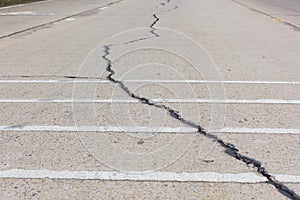 Road crack, surface of concrete driveway with crack and grass