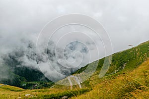 The road that crosses the Fagaras mountains seen from above among the fog, Transfagarasan, Romania