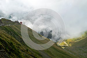 The road that crosses the Fagaras mountains seen from above among the fog, Transfagarasan, Romania