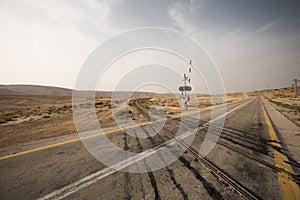 Road crossing rail in desert