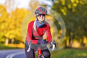 Road Cycling Ideas. Winsome Female Cyclist In Warm Outfit Posing On Road Bike While Smiling And Getting Ready For Start Outdoors