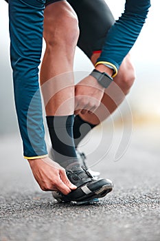 Road, cycling shoes and man cyclist on a fitness trip for a marathon in the city for training. Sports, exercise and male