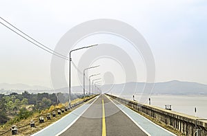 The road on the dam Background mountains and water at Krasiew dam ,Supanburi Thailand