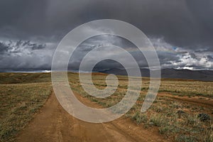 Road dirt steppe rainbow mountains clouds