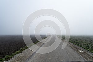 Road disappearing into fog.