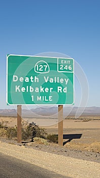 Road distance sign showing exit for Death Valley in Mojave desert, on the Interstate to Las Vegas, California, USA