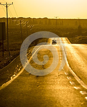 A road at dusk with an aproaching car