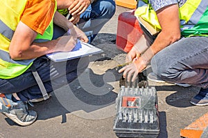 Road engineers measure the thickness of the laid asphalt and record the data in a spreadsheet