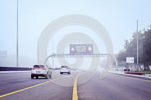 Road in the fog, sign mention keep distance for motorists at dubai road, foggy weather in UAE, Dense Fog keep Safe Distance banner