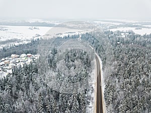 Road through the forest. Aerial view winter landscape