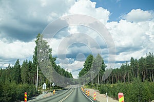 Road and forest with blue sky and clouds