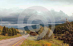 Road in forest under a blue sky with white clouds Sayan mountains Siberia Russia