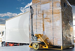 Road freight cargo shipment by truck. Large shipments pallet goods waiting for load into container shipping truck.