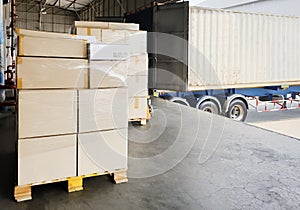 Road freight cargo transport by truck. Shipments boxes on pallet waiting for load into container shipping truck.