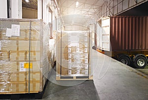 Road freight cargo transport by truck. Shipments boxes on pallet waiting for load into container shipping truck