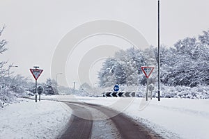 Road with give way signs in the snow