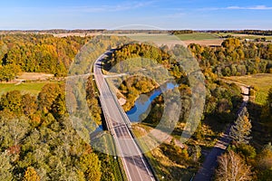 The road goes through a small beautiful river and a small forest. Travel around Europe