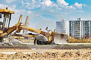 Road grader at the construction site. Powerful construction machine for ground leveling and excavation. Close-up. Professional