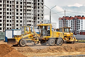 Road grader at the construction site. Powerful construction machine for ground leveling and excavation. Close-up. Professional