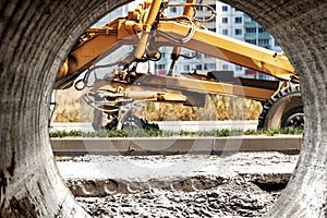 Road grader at the construction site. Powerful construction machine for ground leveling and excavation. Close-up. Professional