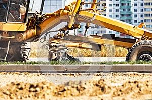 Road grader at the construction site. Powerful construction machine for ground leveling and excavation. Close-up. Professional