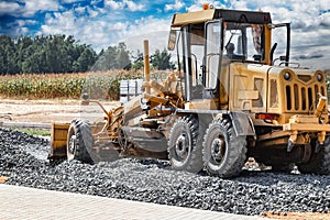 Road grader at the construction site. Powerful construction machine for ground leveling and excavation. Close-up. Professional