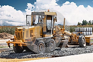 Road grader at the construction site. Powerful construction machine for ground leveling and excavation. Close-up. Professional