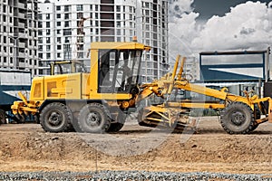 Road grader at the construction site. Powerful construction machine for ground leveling and excavation. Close-up. Professional