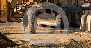 Road grader working at construction site for maintenance and construction of dirts and gravel road. Yellow motor grader. Heavy