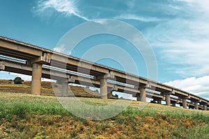 Road highway bridge, viaduct supports in the valley among the green hills, transport infrastructure