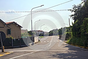 Road with houses and trees in the italian coutryside on a sunny day