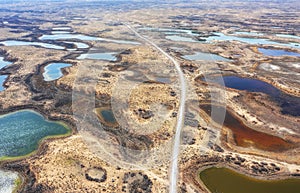 The road among of hundreds of small steppe multi-colored lakes in the delta of the Topar River,