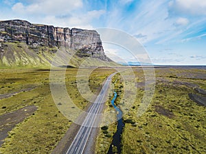 Road in Iceland near big cliff, aerial view from above, South Coast