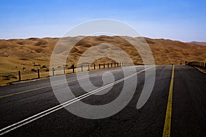 Road leading through sand dunes in the desert of Liwa Oasis United Arab Emirates