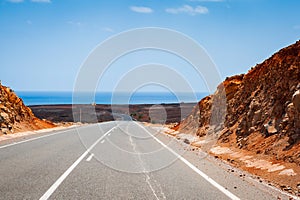 Road leading to horizon trough the dusty landscape of Boa Vista island.