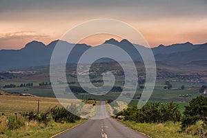 A road leading towards the Drakensberg mountains at sunrise near Clarens