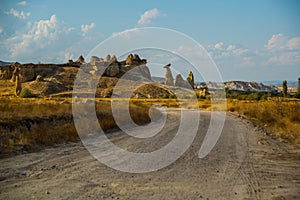 The road leads to the mountains and rocks shaped like mushrooms. Fairy chimneys. Cappadocia, Turkey