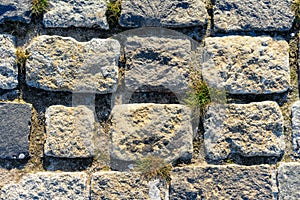 Road lined with rough rough gray stone as background or texture.