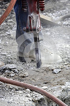 Road maintenance worker using a jackhammer