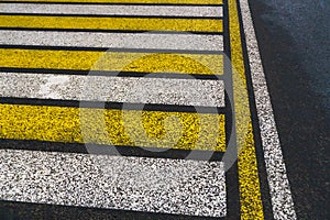 Road markings on wet asphalt. White yellow zebra for pedestrian safety. Pedestrian crossing. A copy place