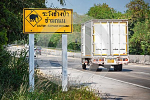 Road metal sign Caution elephants crossing text Caution elephant crossing Thailand countryside