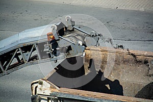 Road milling machine is loading the truck by asphalt powder.