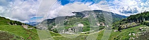 A road in the mountains of Dagestan with large mountains in the background and clouds. Russia.