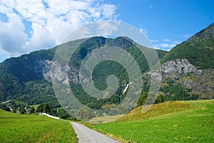 Road in mountains in Flam, Norway. Country road on mountain landscape. Beauty of nature. Hiking and camping. Summer trip